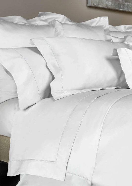 White bedding set with pillows on a bed