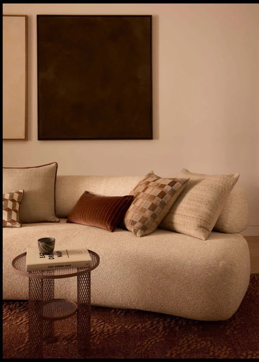 Beige sofa with patterned cushions in a living room setting