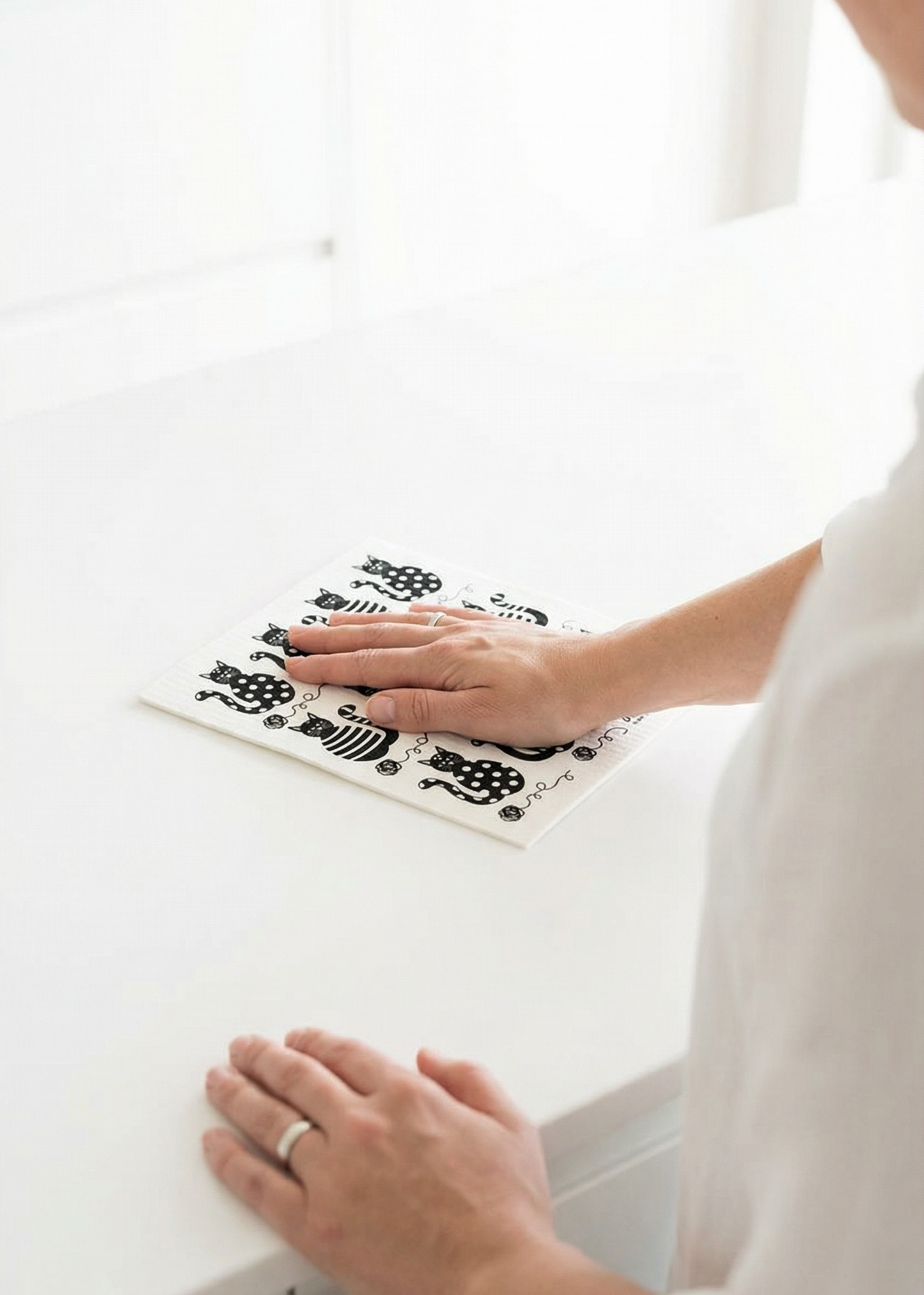 Person applying a decorative sticker to a white surface