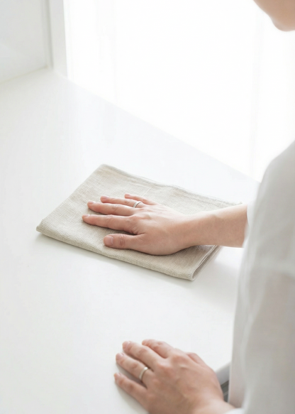 Person cleaning a white surface with a cloth