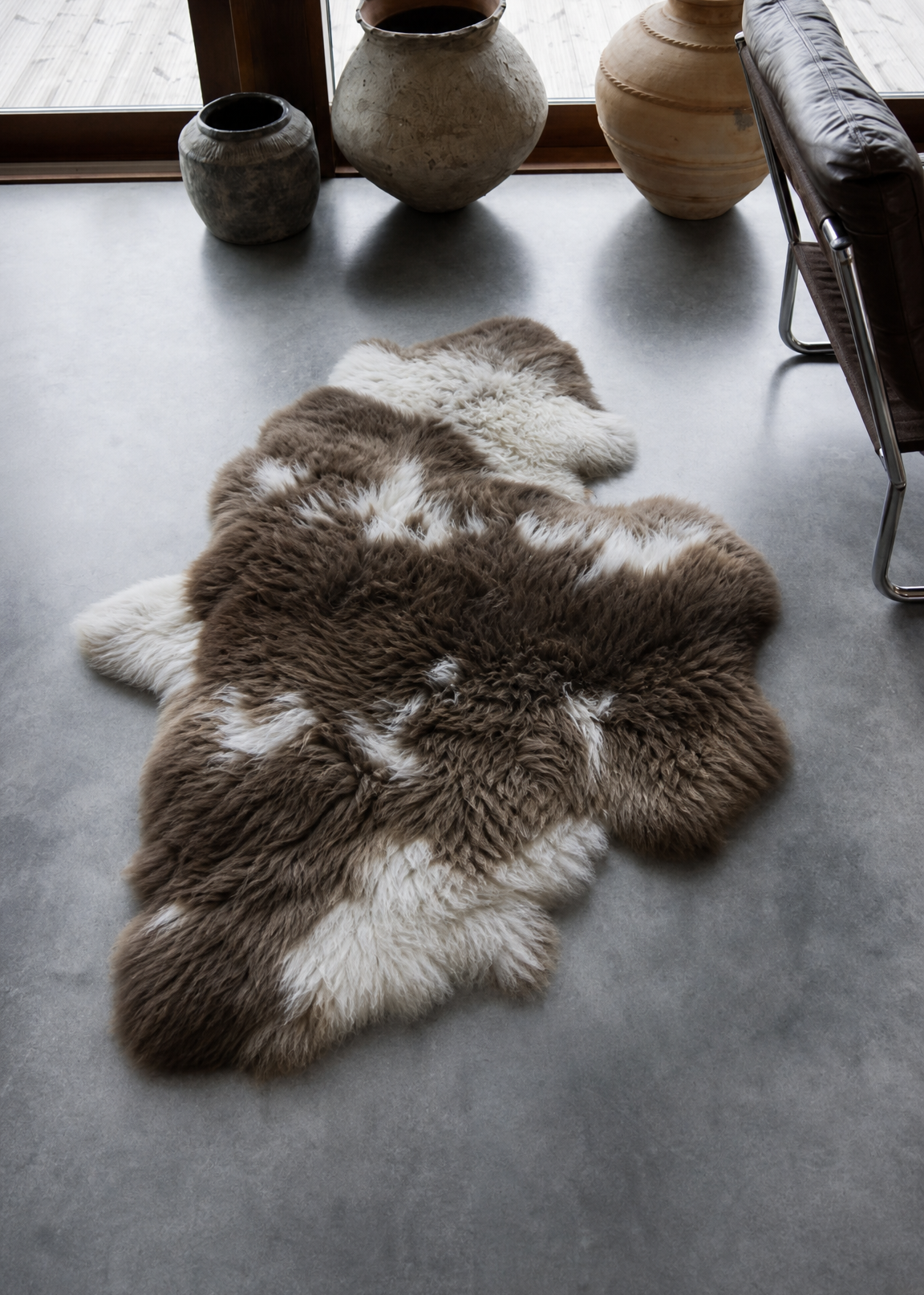 Fur rug on a concrete floor with decorative vases in the background