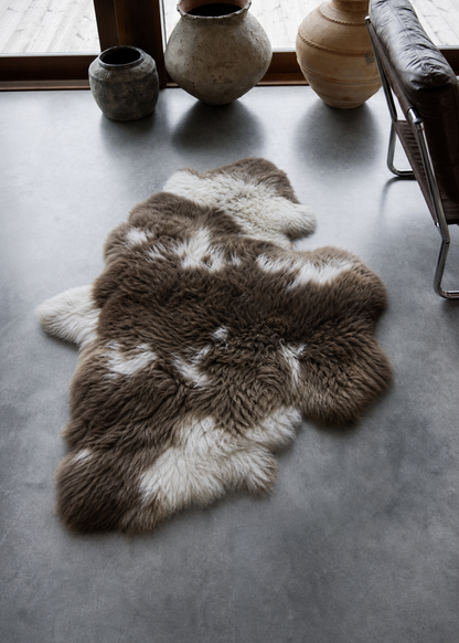 Fur rug on a concrete floor with decorative vases in the background