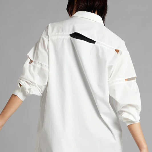 Person wearing a white jacket with black accents on a gray background