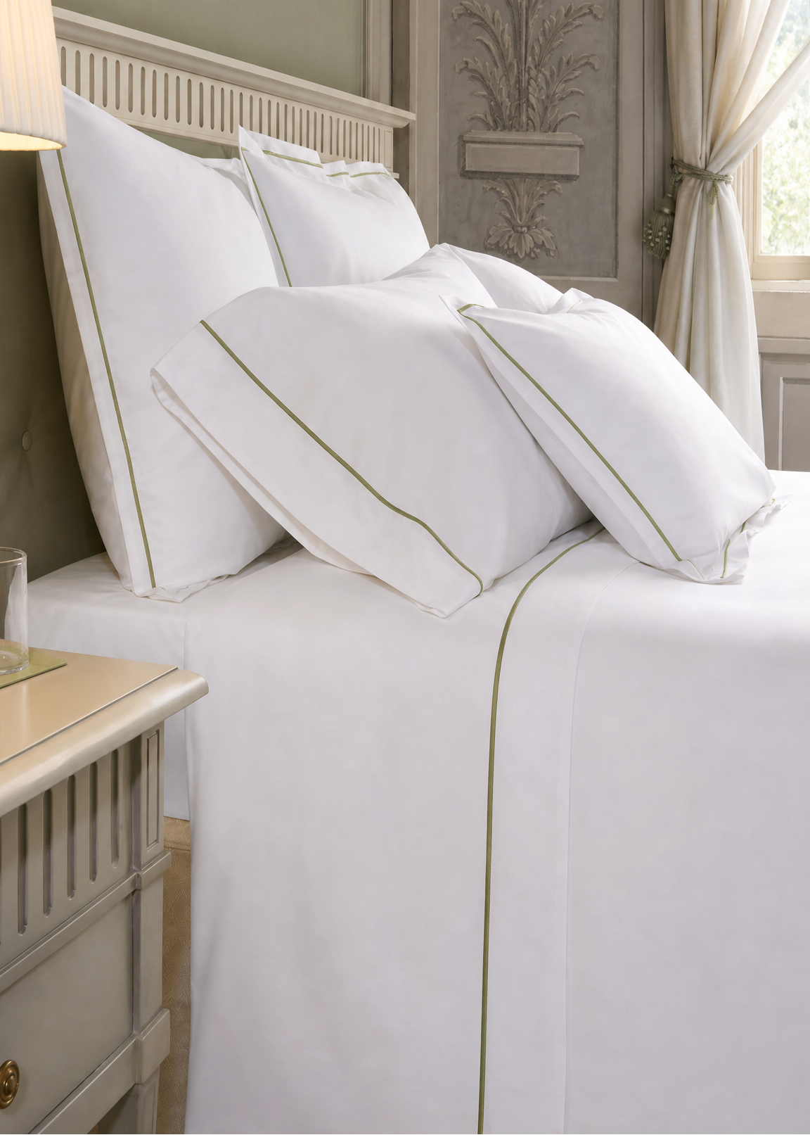 White bed sheets and pillows on a neatly made bed in a bedroom.