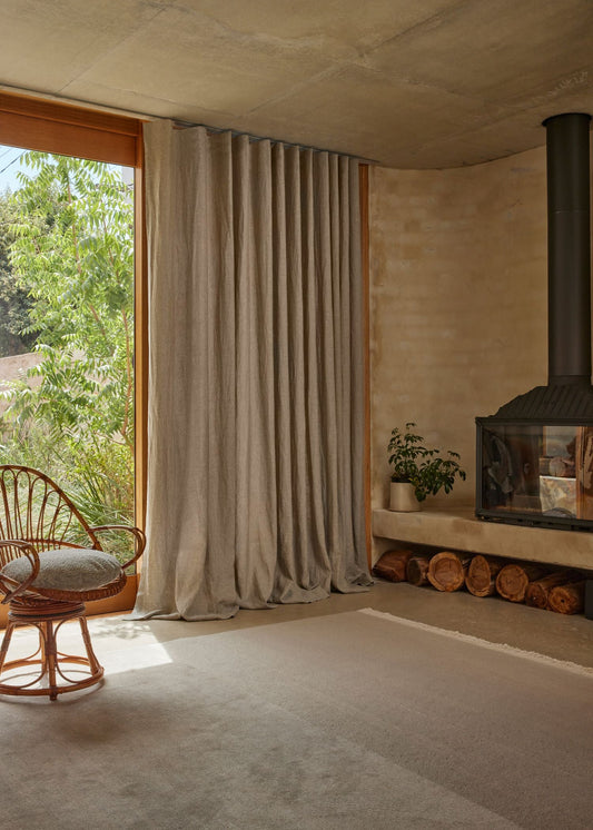 Cozy room with a fireplace, curtain, and wicker chair.