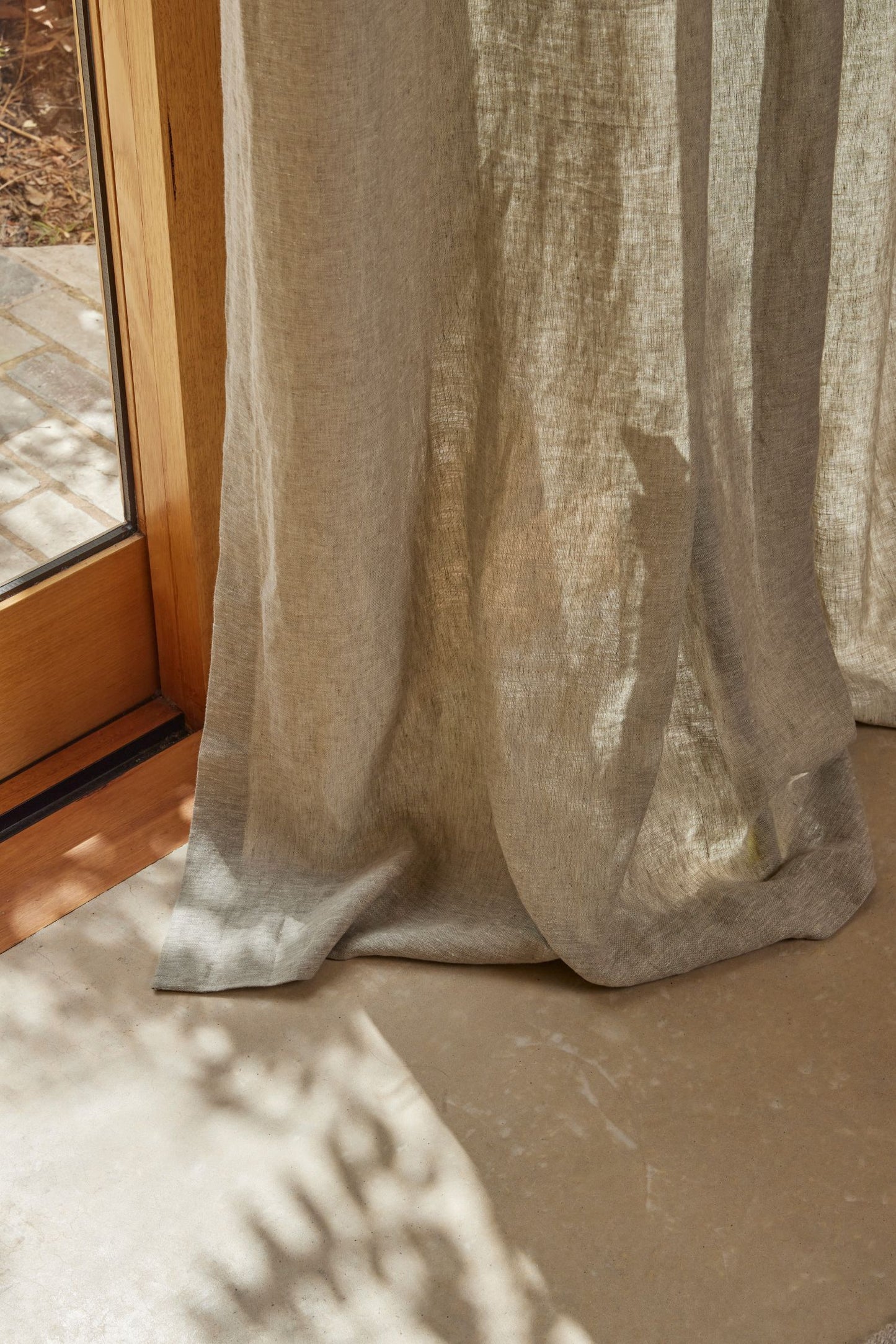 Sheer beige curtain in front of a window with natural light