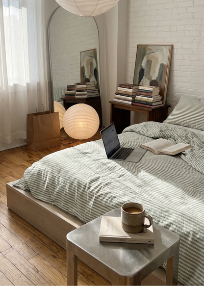 Modern bedroom with bed, laptop, and decor elements.