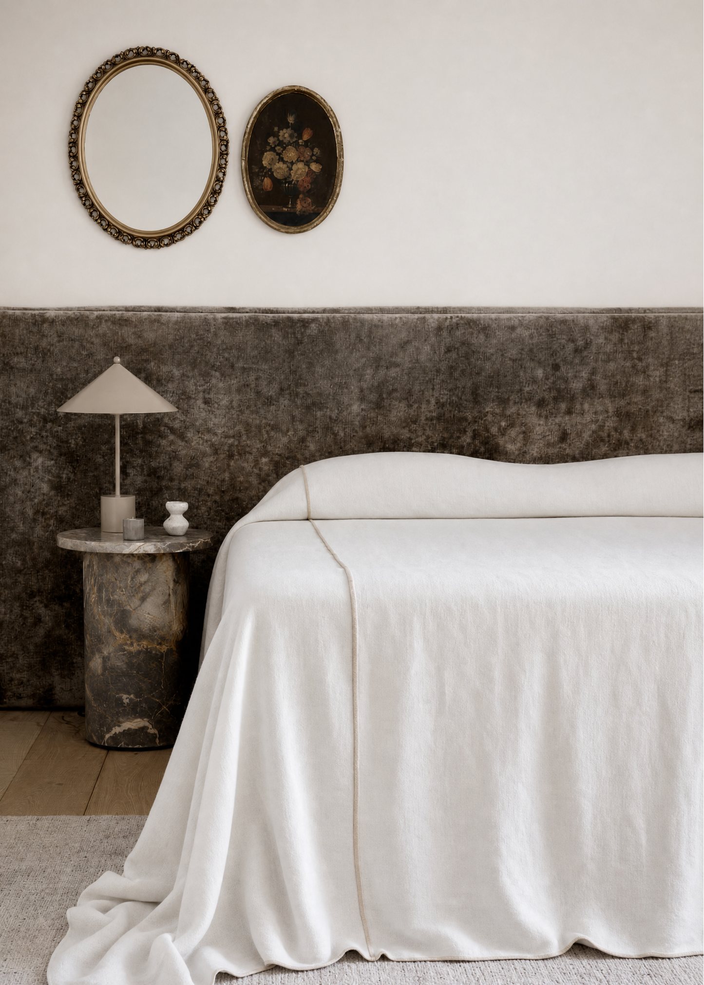 Bedroom with a large bed, side table, and decorative mirrors on the wall.