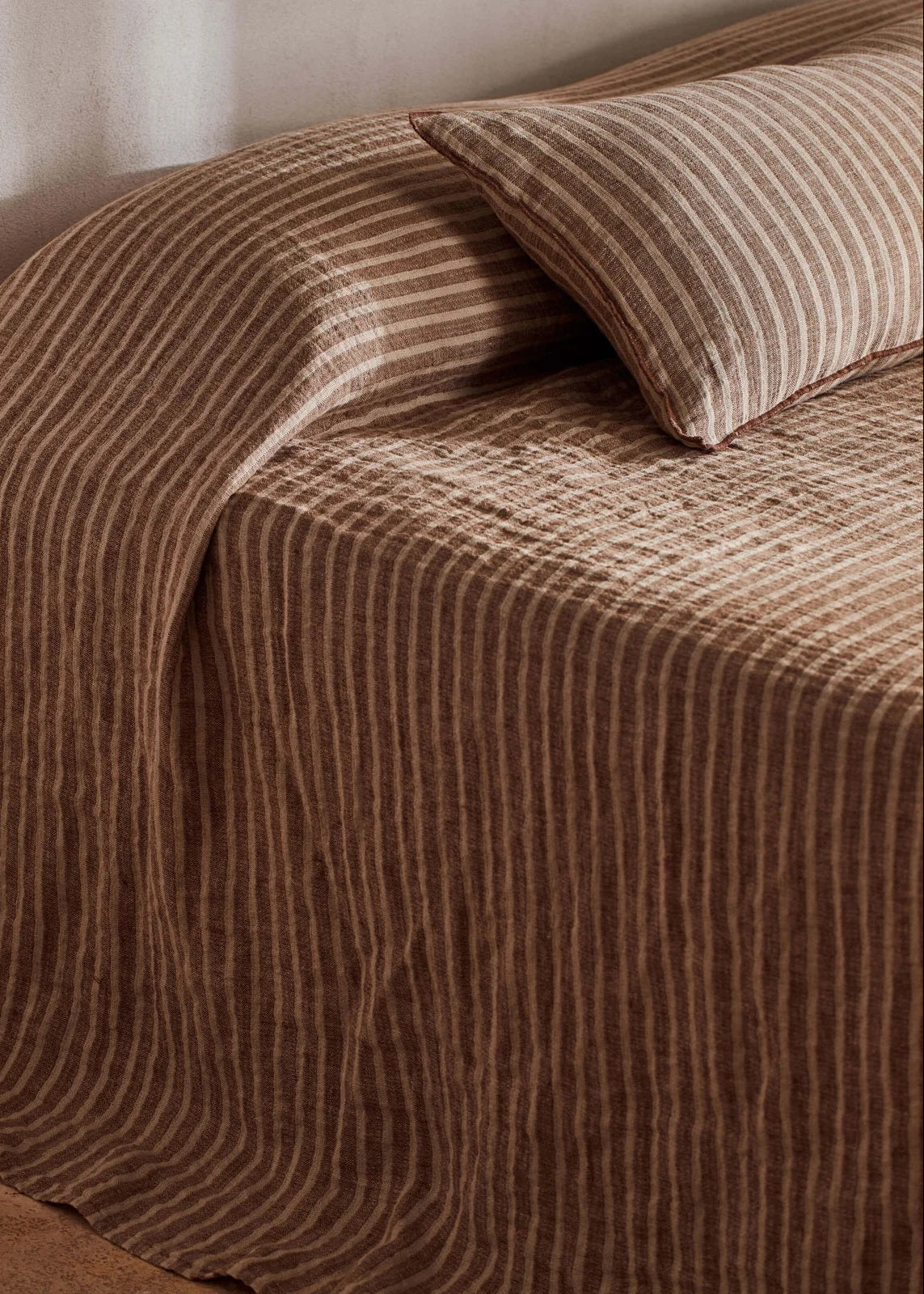 Brown textured bedspread on a bed with a pillow