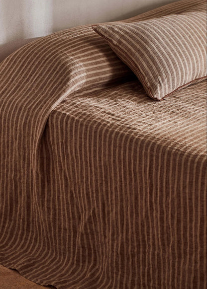 Brown textured bedspread on a bed with a pillow