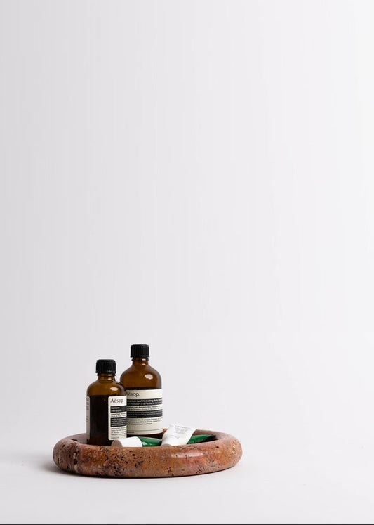 Two bottles on a wooden tray with a white background