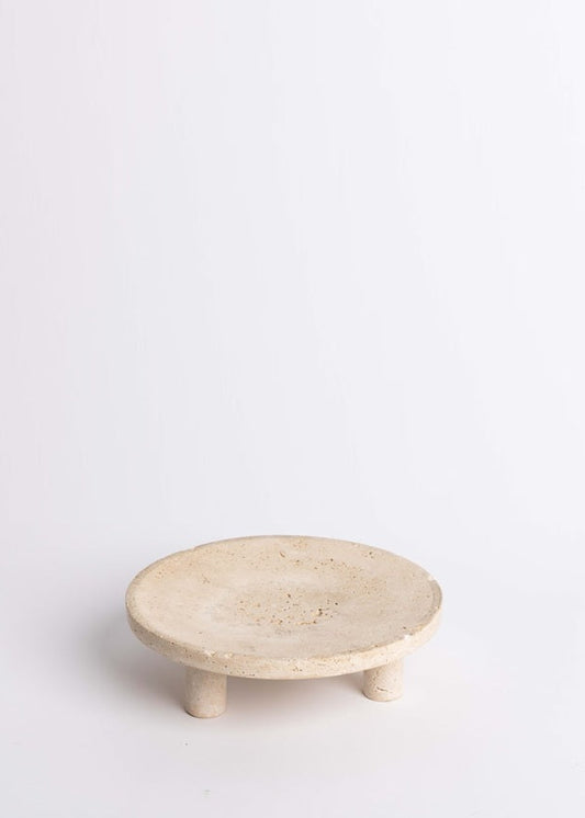 Round beige stone trivet on a white background