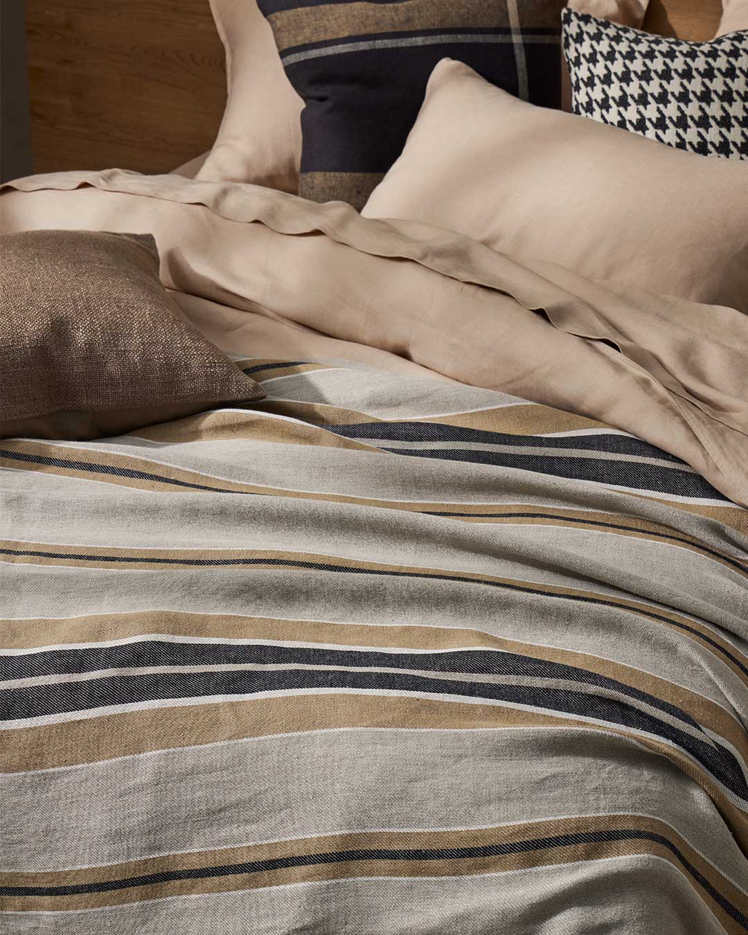 Close-up of striped bedding with pillows in a bedroom setting