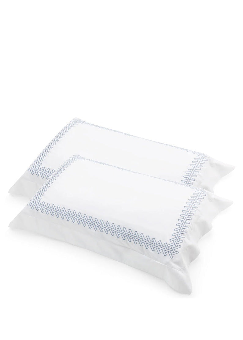 Two white pillows with blue embroidery on a white background