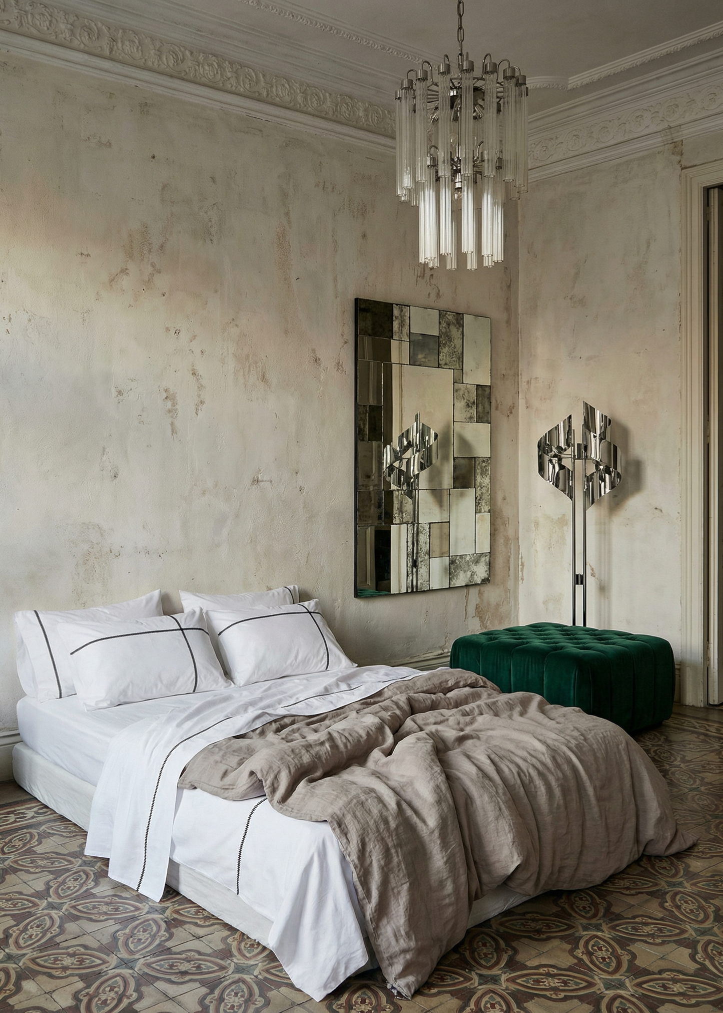 Luxurious bedroom with a chandelier, large mirror, and patterned floor.
