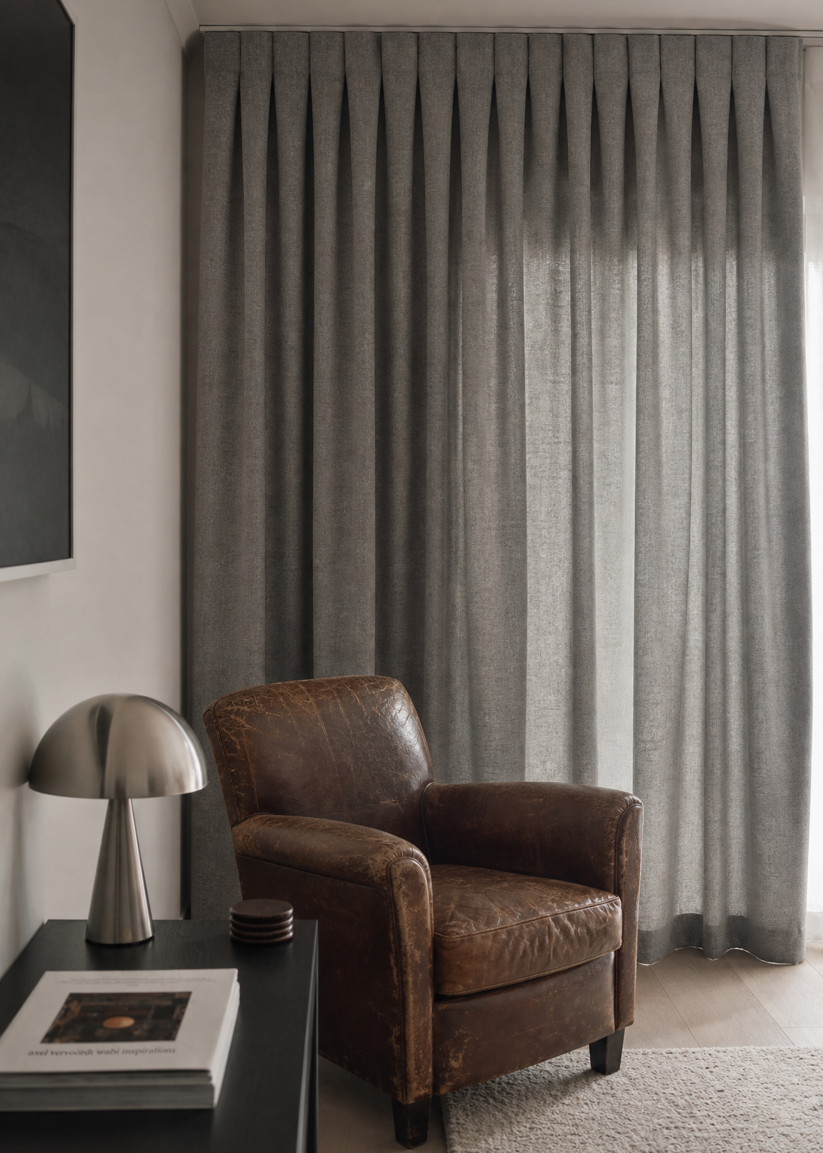 Modern interior with a white chair, side table, and curtain.