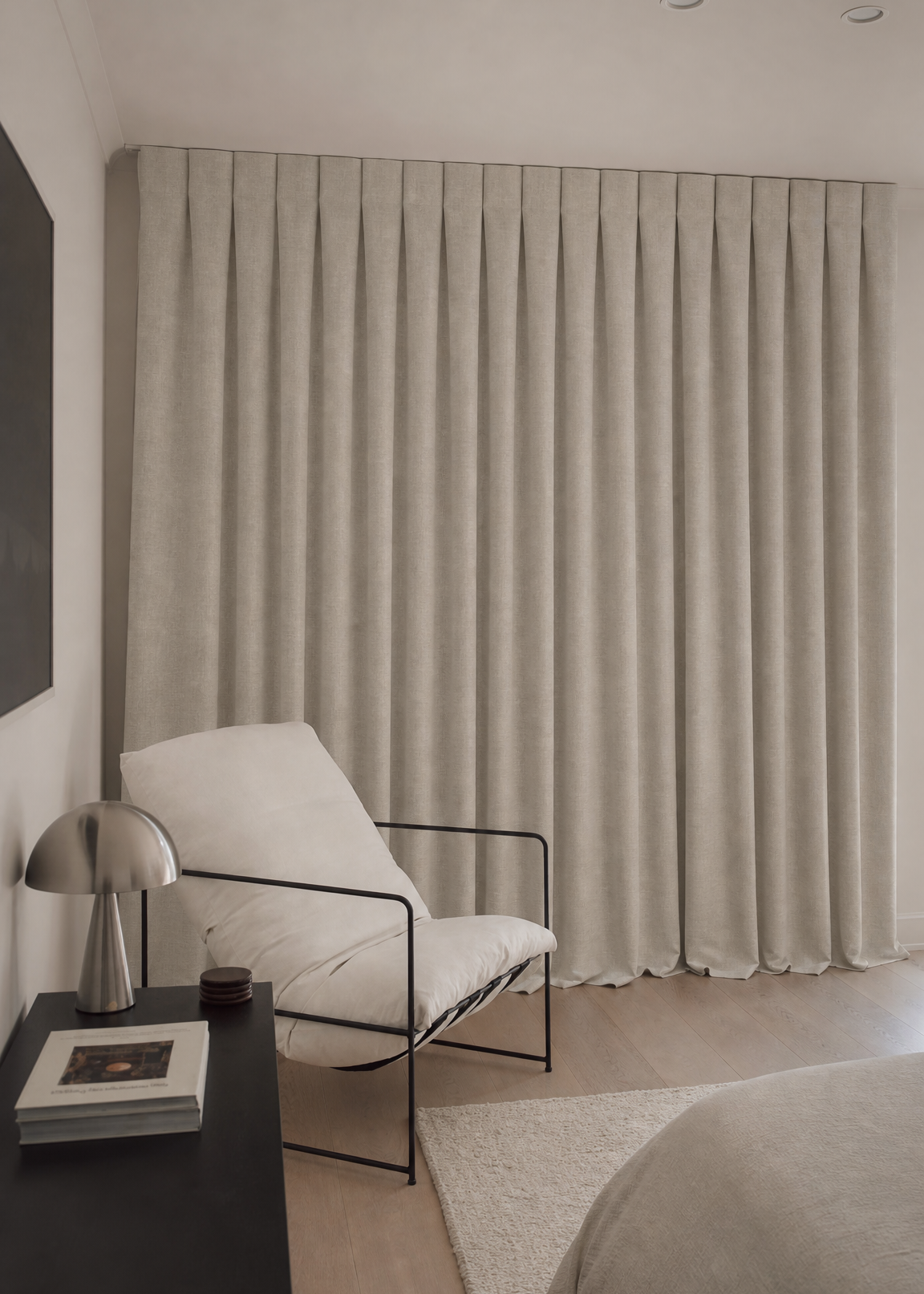 Modern interior with a white chair, side table, and large curtain.