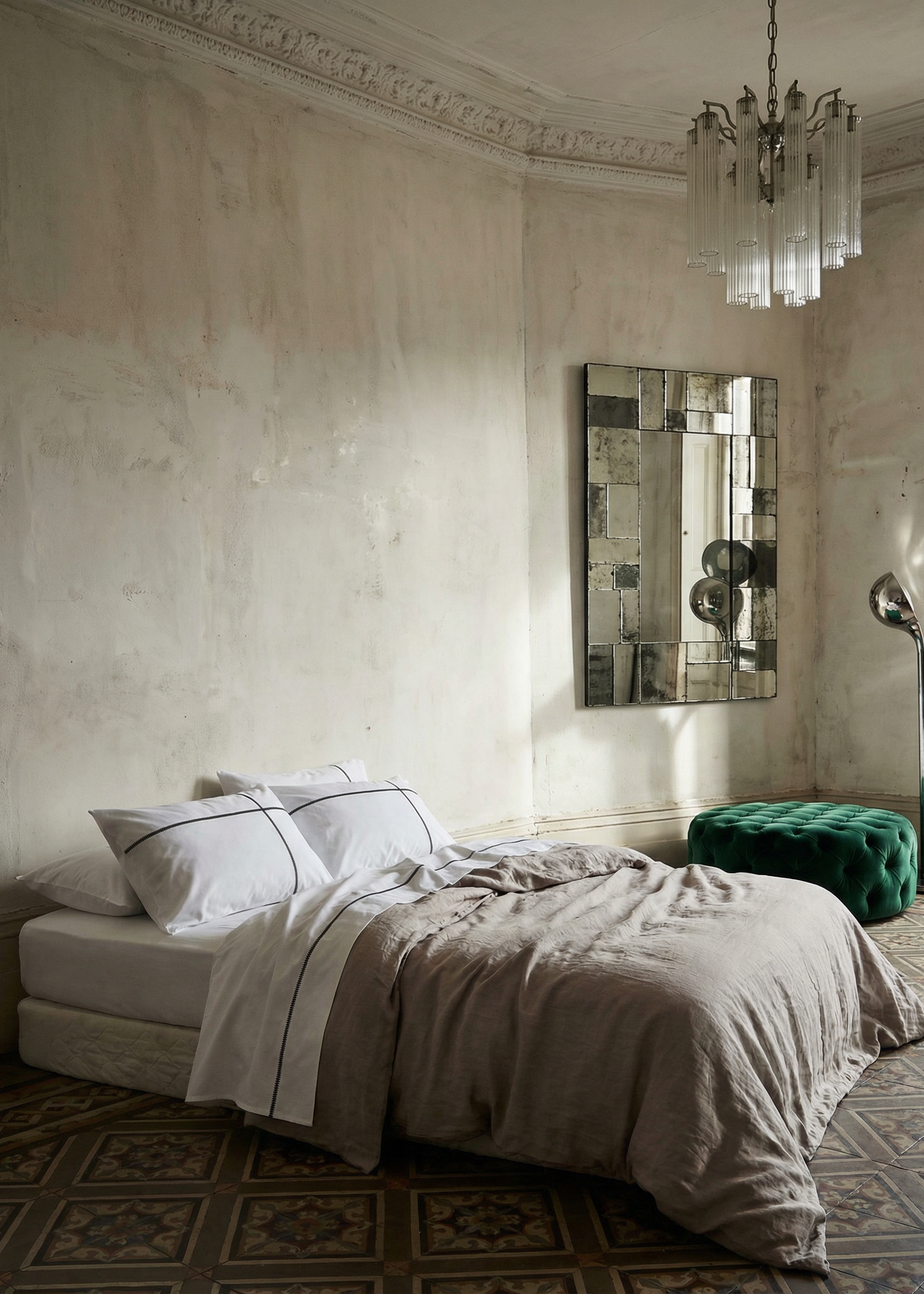 Luxurious bedroom with a bed, mirror, and chandelier.