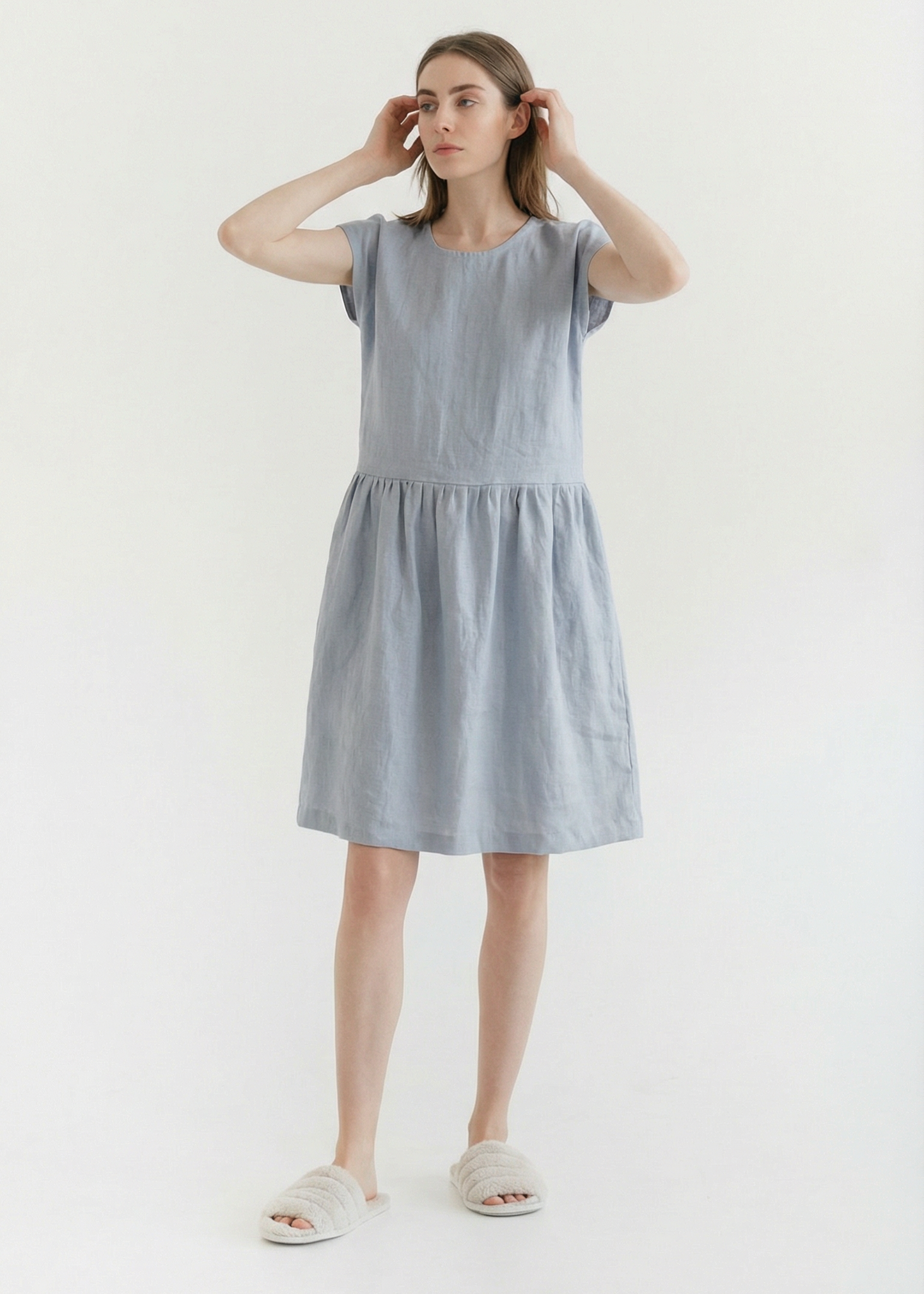 Woman wearing a light blue dress on a white background