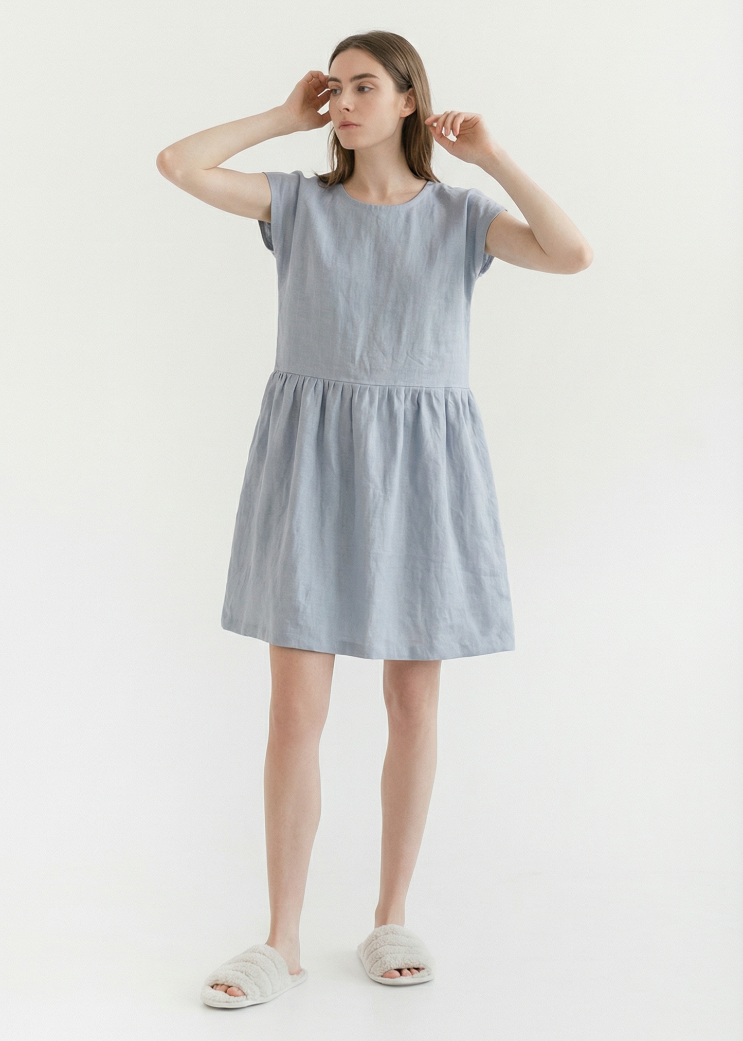 Woman wearing a light blue dress on a white background