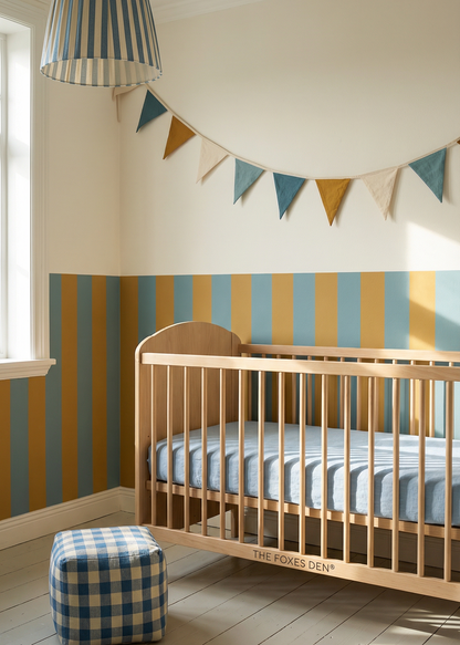 Nursery room with wooden crib, striped wallpaper, and colorful flags.