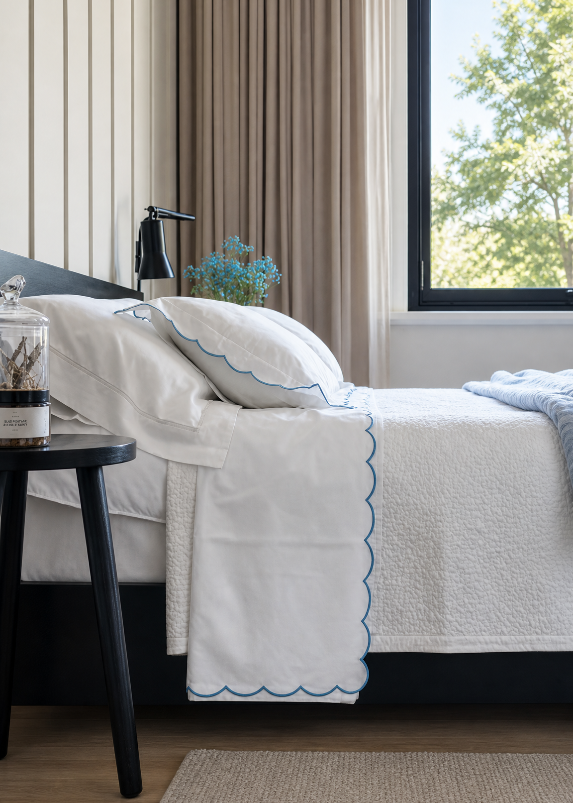 Bedroom with a neatly made bed and a window showing greenery outside.