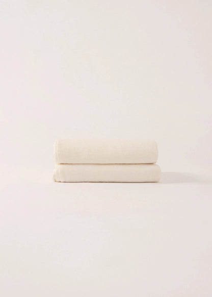 Stack of white towels on a light pink background