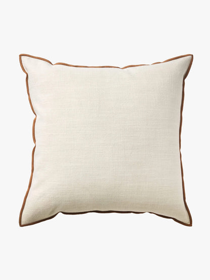 A square off-white linen throw pillow with a contrasting brown piped edge, shown against a plain white background.