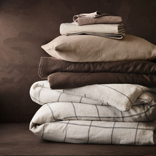 Stack of folded bedding on a dark background