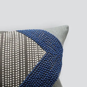 Decorative pillow with geometric pattern on a light gray background
