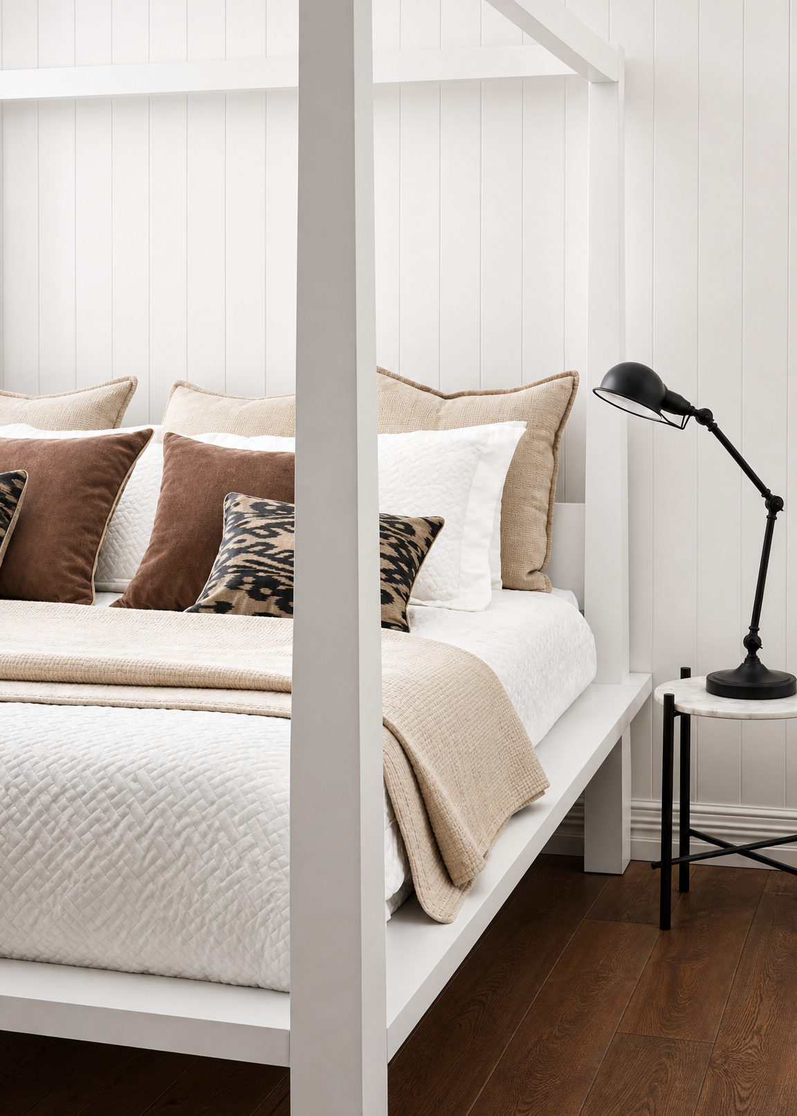 Bedroom with a white bed frame, beige bedding, and decorative pillows.