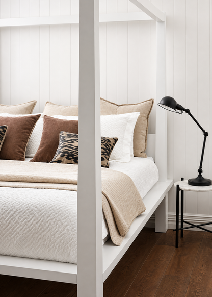 Bedroom with a white bed frame, beige bedding, and decorative pillows.