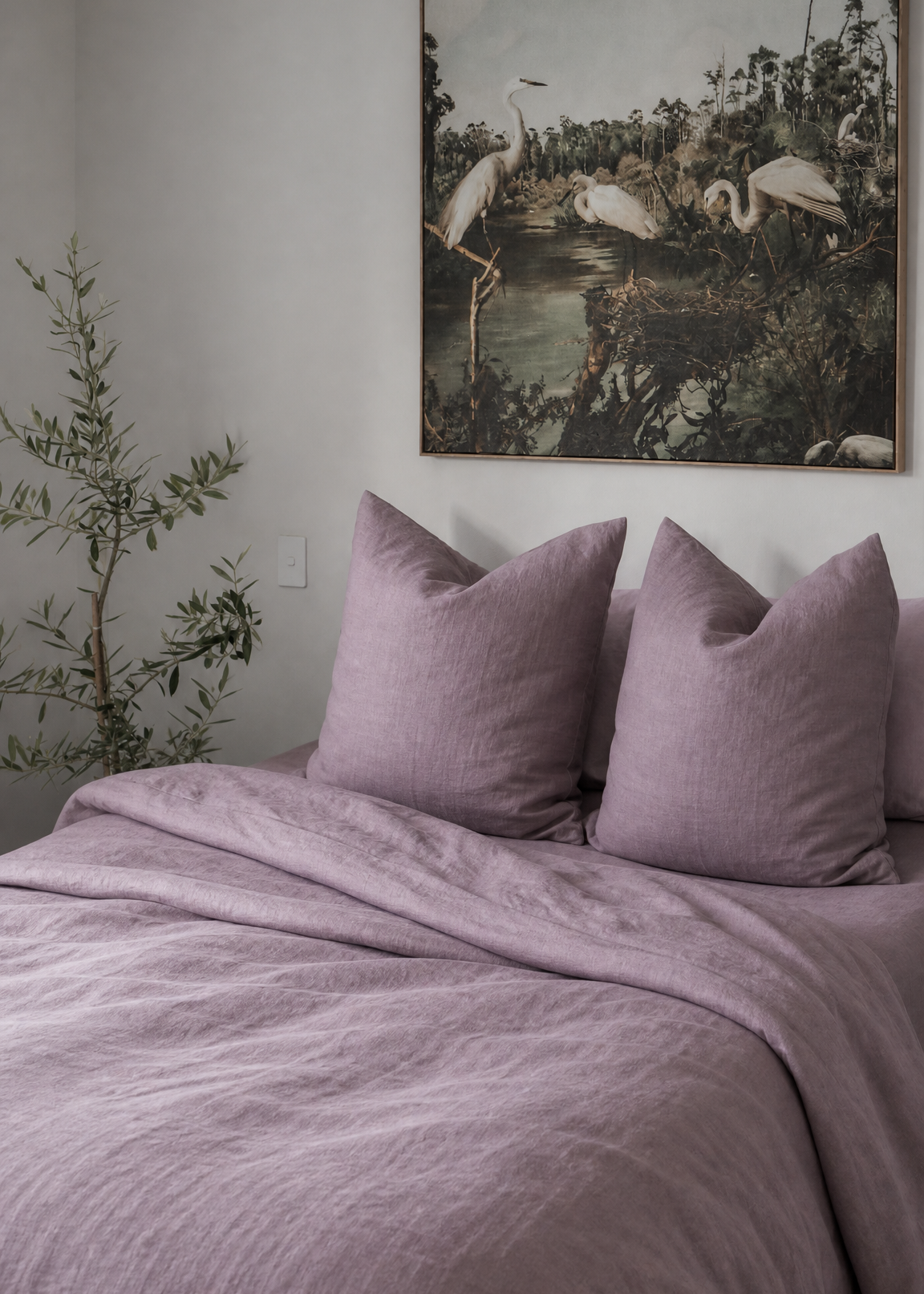 Bedroom with purple bedding and a large wall art piece of birds.