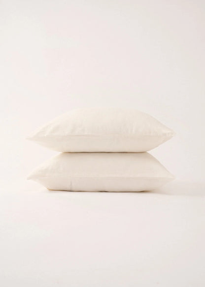 Two beige pillows stacked on a light gray background