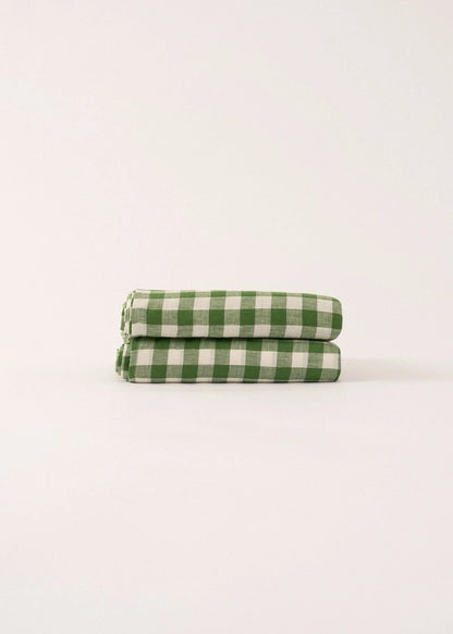 Two green and white checkered towels stacked on a light beige background