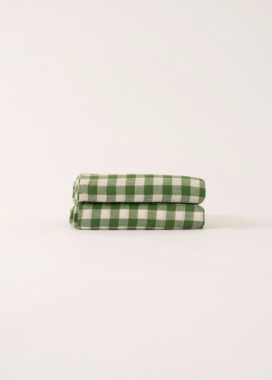 Two green and white checkered towels stacked on a light beige background
