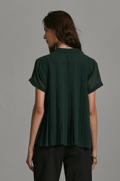 Woman wearing a dark green blouse against a gray background