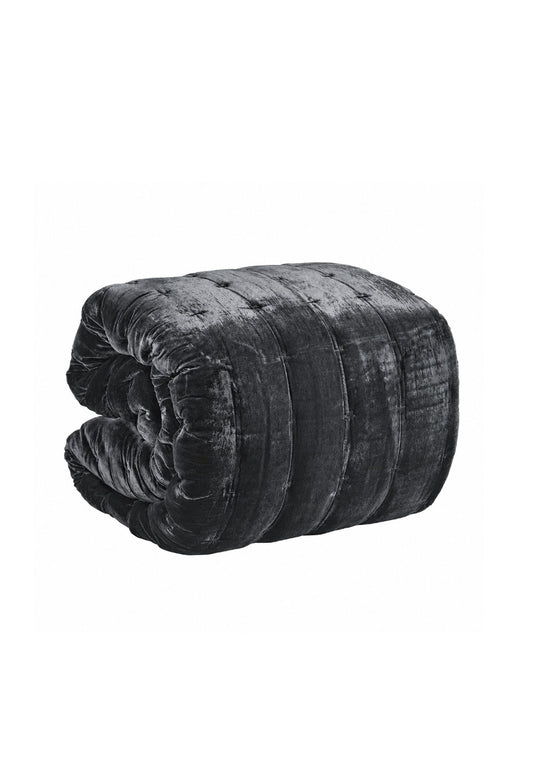 A rolled black velvet quilt or comforter with a tufted button design, shown on a plain white background.