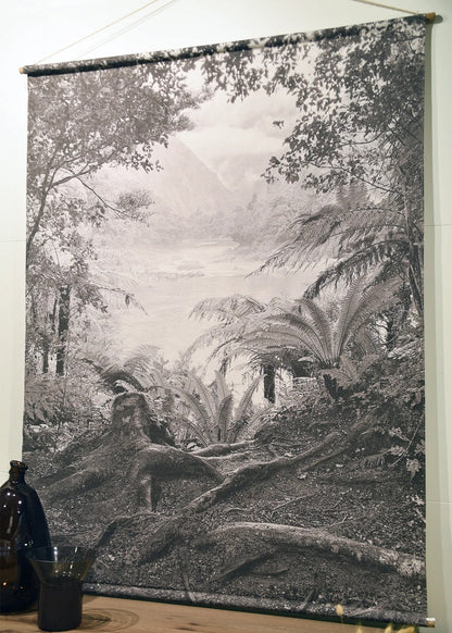 Tapestry of a forest scene hanging on a wall with a wooden shelf below.