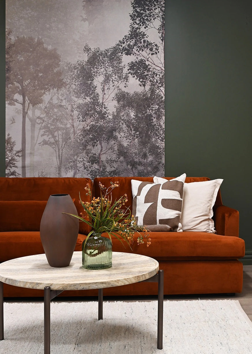 Living room with a brown sofa, decorative pillows, and a coffee table with a vase and plants.