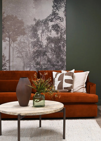 Living room with a brown sofa, decorative pillows, and a coffee table with a vase and plants.