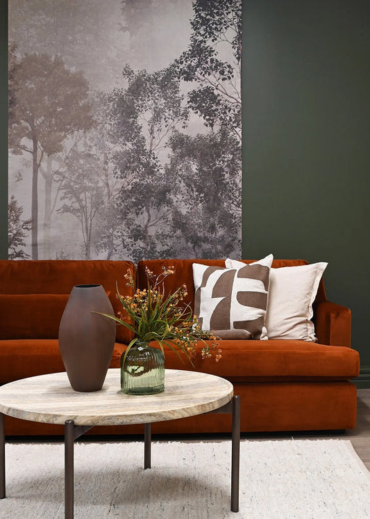 Living room with a brown sofa, decorative pillows, and a coffee table with a vase and plants.