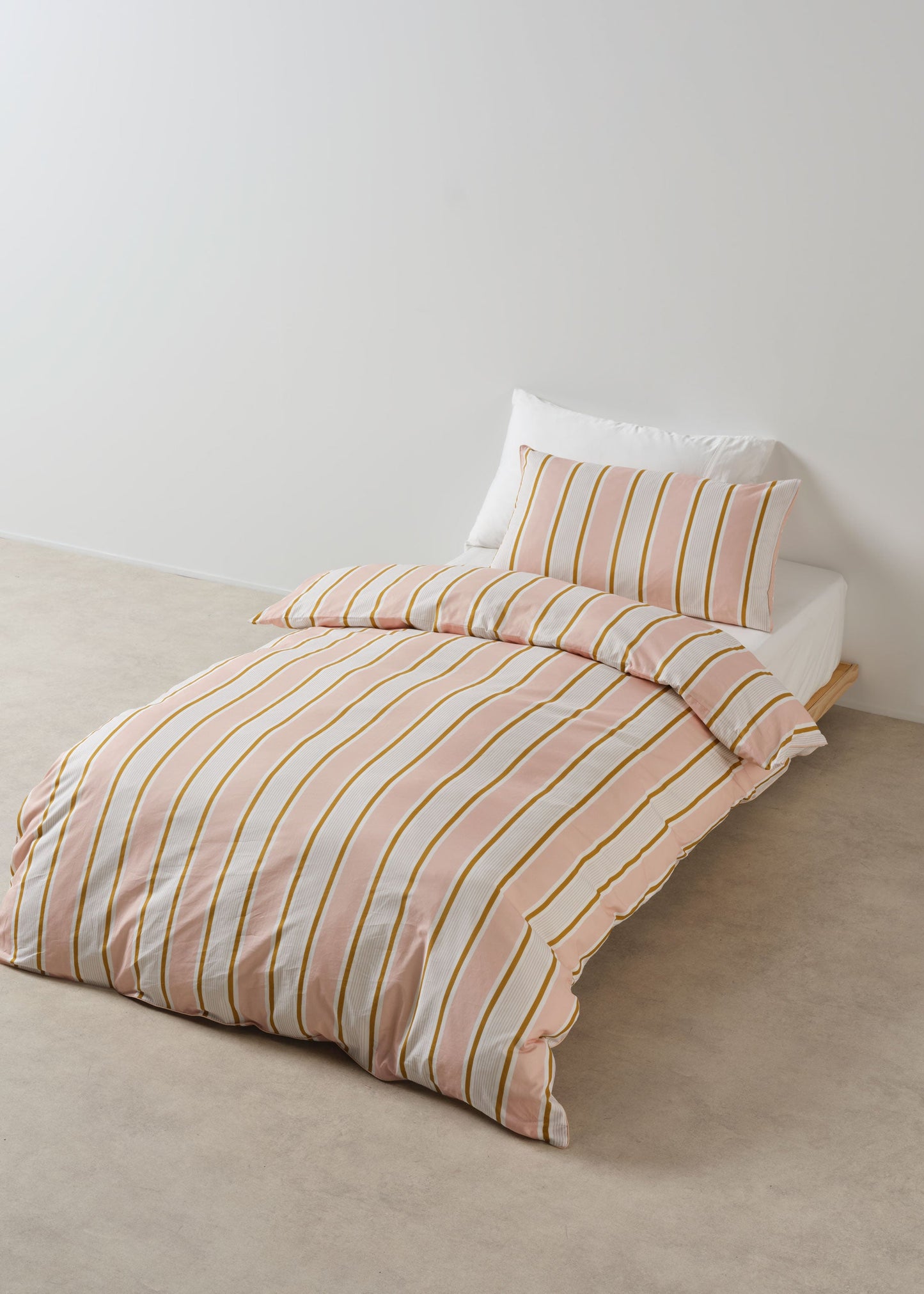 Striped bedding set on a bed with a plain background