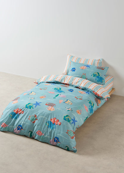 Children's bed with blue bedding featuring sea-themed patterns on a plain background