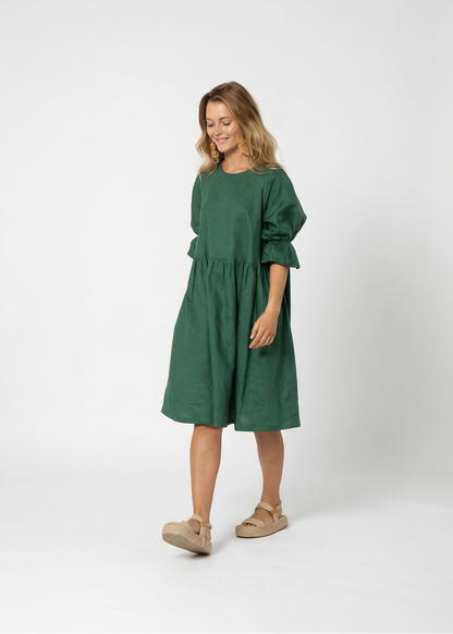 Woman wearing a green dress standing against a white background