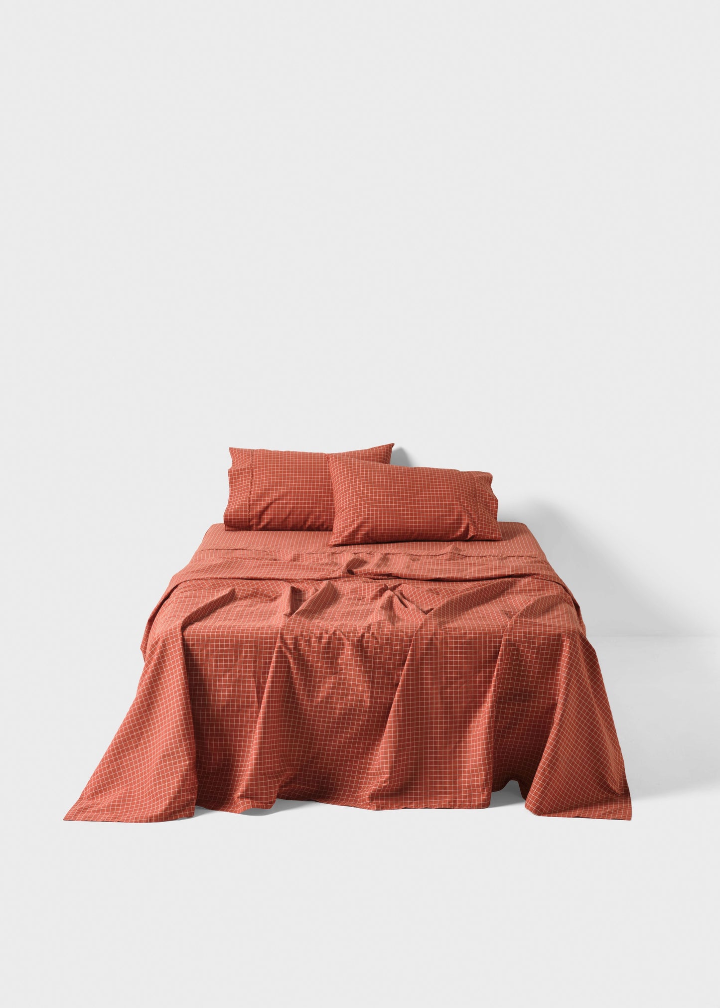 Red checkered bedspread and pillows on a white background