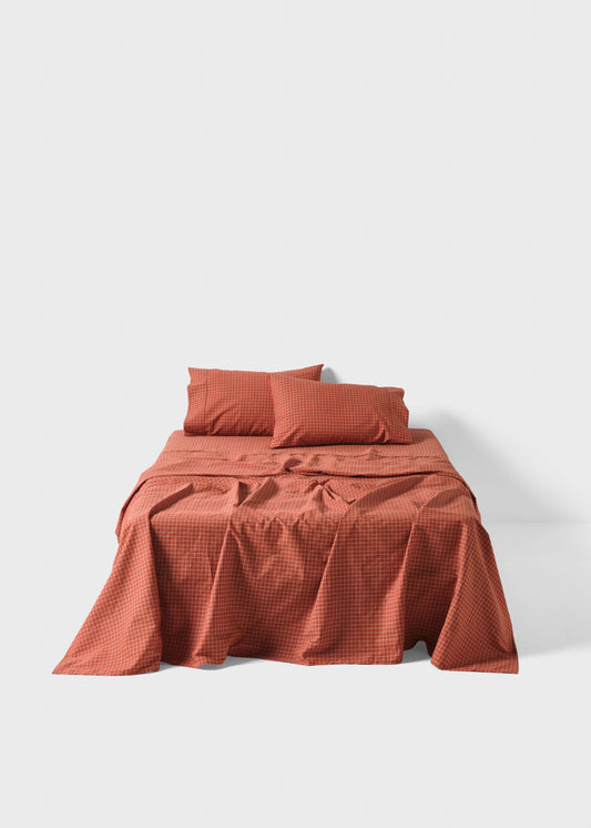 Red checkered bedspread and pillows on a white background