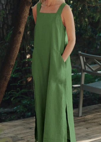 Woman in a green dress standing on a wooden deck with greenery in the background