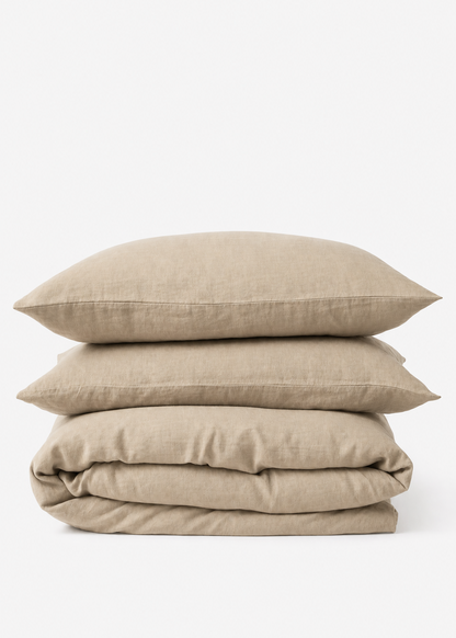 Beige bedding set with duvet and pillows on a white background