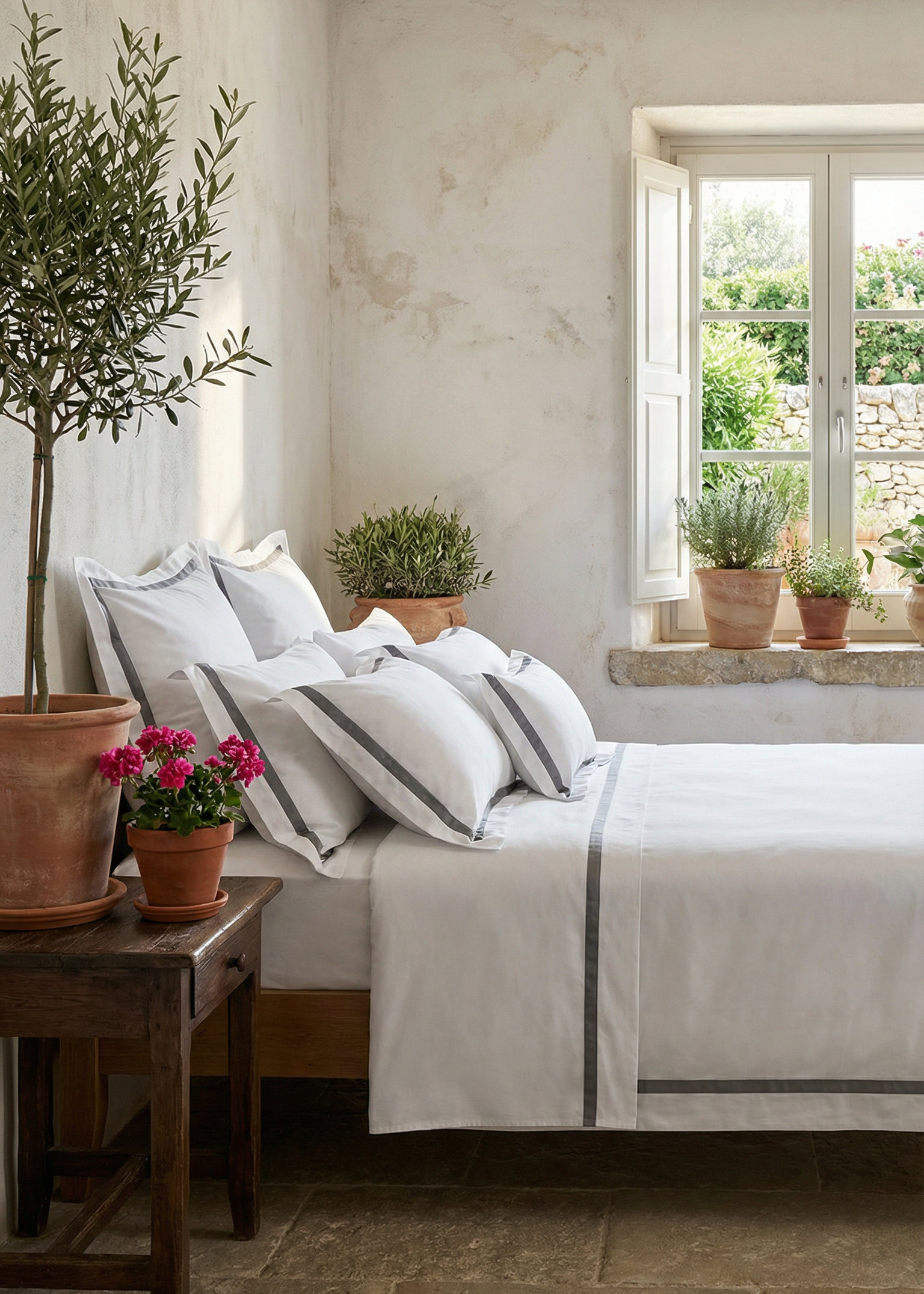 Cozy bedroom with a bed, side table, and potted plants.